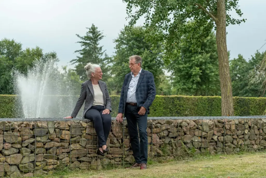 Martin Uitendaal en Sonja Raijmakers bij een fontein in een tuin