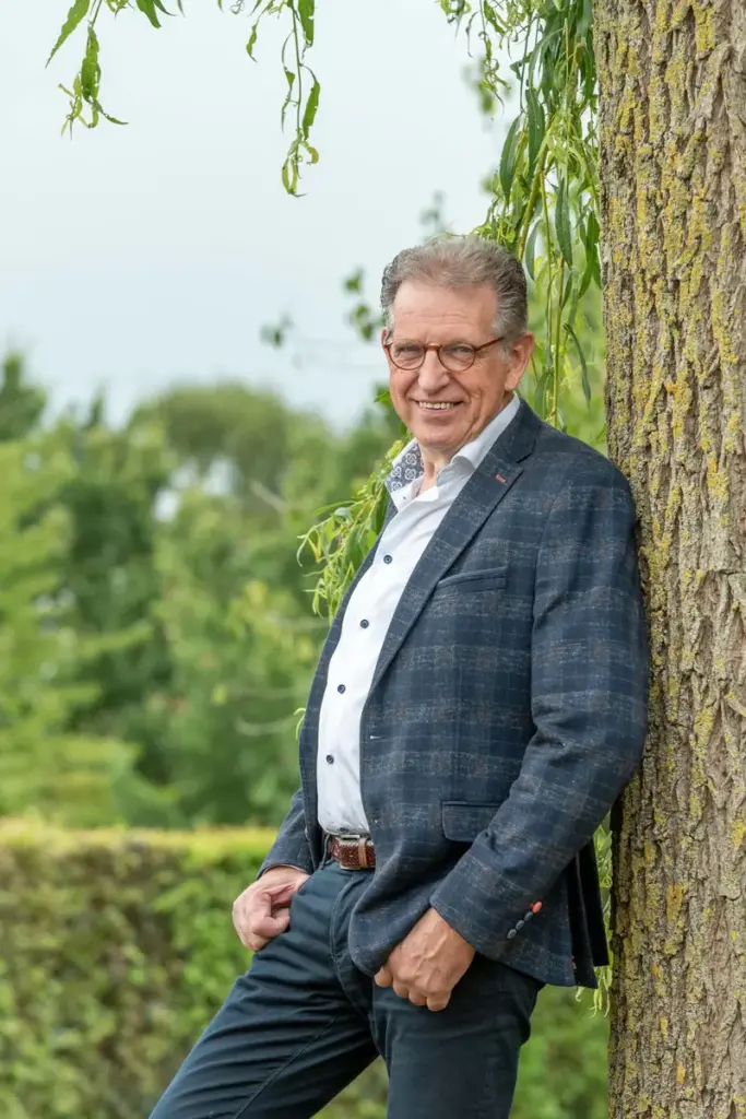 Martin Uitendaal staat tegen een boom in een park