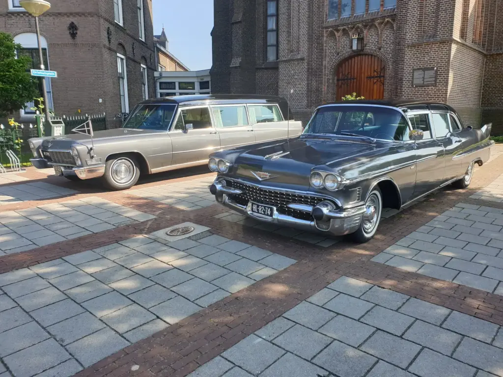 Twee klassieke Cadillacs van Uitvaartverzorging Uitendaal voor een kerk